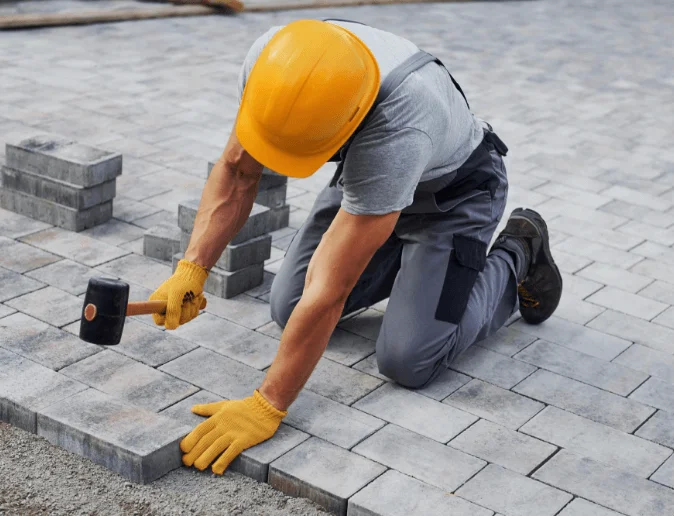uses-rubber-hammer-male-worker-yellow-colored-uniform-have-job-with-pavement